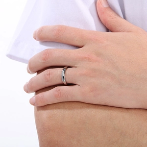 Close-up of a silver-colored minimalist smooth stainless steel ring on a hand