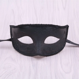 Detail of vintage black masquerade mask with glitter swirls and woven lace trim