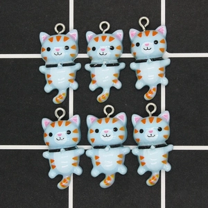 Detail view of light blue resin cat charms with orange stripes for DIY jewelry making