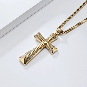 Macro detail of gold plated hip hop cross necklace with sparkling inlaid diamonds