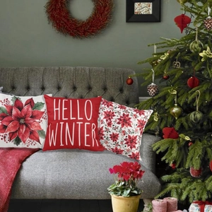 Three Christmas throw pillow covers with festive red floral and Hello Winter patterns