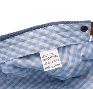 Detail view of cotton blend newsboy cap inner lining with blue gingham pattern and care label