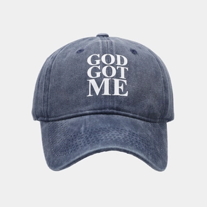Dettaglio del cappellino da baseball in denim lavato blu scuro con ricamo bianco