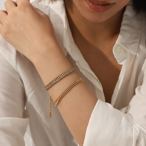 Detail of 18K gold-plated double-layer bracelet with sparkling white cubic zirconia on wrist
