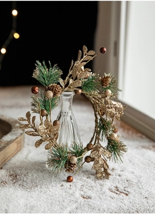 Détail de pommes de pin dorées et couronne de Noël scintillante sur fenêtre enneigée