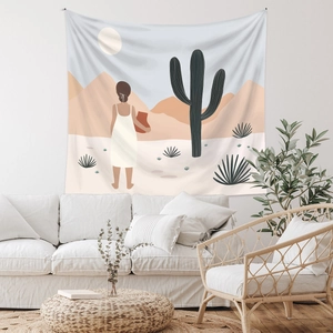 Detail of bohemian tapestry with sunset desert art hanging over a white sofa