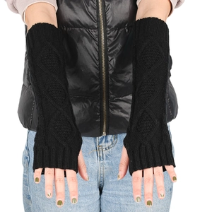 Close-up of black knitted arm warmer featuring classic diamond pattern and ribbed cuffs
