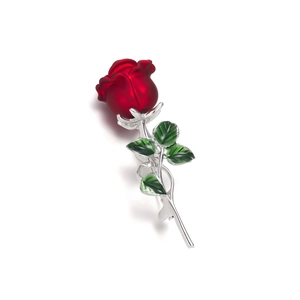 Close-up of elegant red enamel rose brooch with silver stems and green leaves details