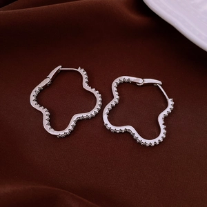 Detailed view of silver four-leaf clover earrings with sparkling cubic zirconia pavé