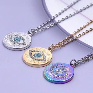 Drei Evil Eye Anhänger Halsketten in Gold, Silber und Regenbogen auf lila Hintergrund