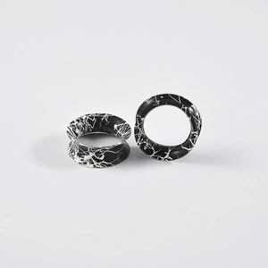 Detailed view of hollow ear gauges with black and white marble ink texture pattern