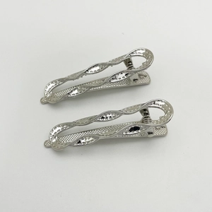 Detail of two silver hollow wave hair clips with metallic luster on gray background