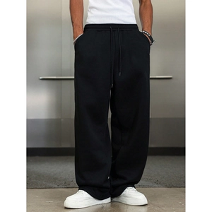 Detail view of men's black wide-leg joggers with drawstring waist and heavy cotton texture