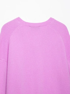 Detail shot of crew neckline and raglan sleeves on pink purple knit sweater top