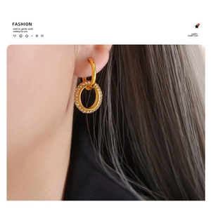 Detailed close-up of a gold-plated titanium steel interlocking double hoop earring with zircons