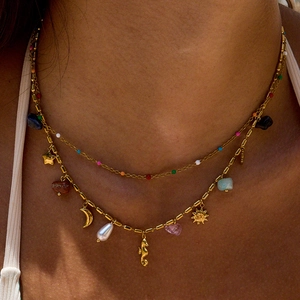 Close-up of double-layer 18K gold plated necklace with pearl and colorful charms on model