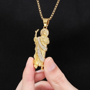 Vue macro du pendentif Saint Jude doré orné de détails en strass étincelants