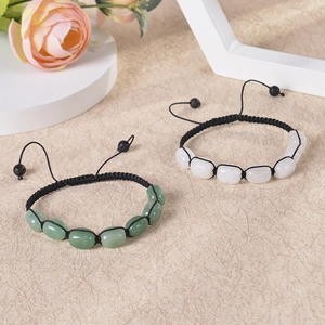 Detail of handmade green and white natural stone beaded bracelets with adjustable black cord