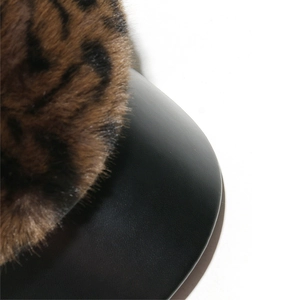 Detail of leopard print faux fur texture and black PU leather brim on newsboy cap