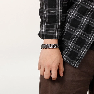 Detail of chunky stainless steel punk curb chain bracelet worn on a male wrist