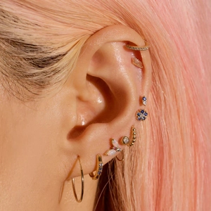 Close-up of gold S925 silver opal studs and hoops with marquise diamonds on an ear