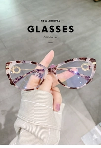 Detail of tortoise shell cat-eye glasses with gold metal temples and anti-blue lenses