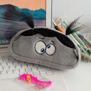 Detail of gray plush stationery bag with cartoon eyes and pink hairstyling accessories