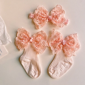 Detail of pink cotton baby socks and lace bow headband set for newborn photography
