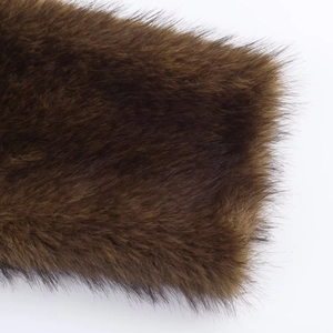 Vue macro montrant la texture douce et les fibres de la veste en fausse fourrure marron