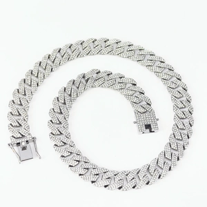 Close-up of a silver Cuban link necklace with sparkling crystals and a detailed clasp