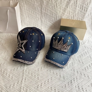 Close-up of denim baseball caps with rhinestone star and crown designs on a soft background