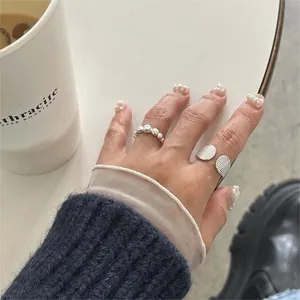 Detailed view of irregular 925 sterling silver open rings on hand with textured finish