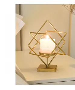Geometric gold iron candle holder with a classic white pillar candle for table decor