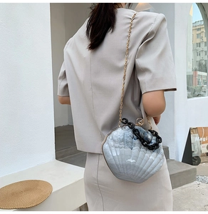 Detailed macro view of shell-shaped acrylic crossbody bag with blue marble texture