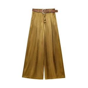 Detail of satin wide-leg trousers in olive gold with a brown decorative belt