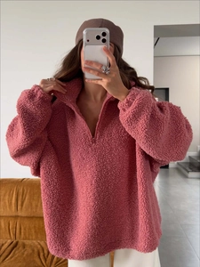 Detail of pink fleece hoodie with half-zip closure and soft textured lamb wool fabric