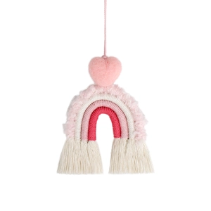 Close-up of pink macrame rainbow car charm with heart pompom and cream fringe tassels