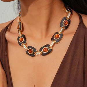 Detailed macro view of vintage gold chain necklace with amber resin and black enamel
