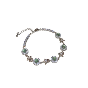 Elegant silver flower bracelet featuring green stones and sparkling star charms