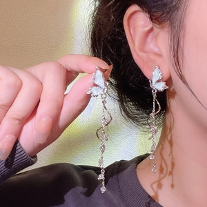 Detailed view of silver butterfly tassel earrings with blue enamel and sparkling crystals