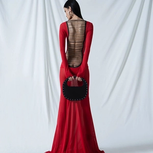Detail of red backless maxi dress featuring intricate black mesh lace-up back design