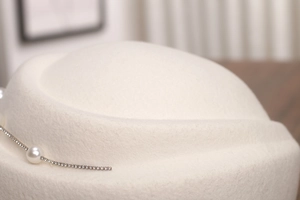 Détail du béret en laine avec perle élégante et chaîne de strass décorative