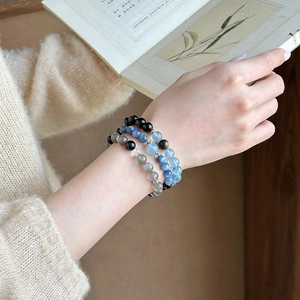 Close-up of beaded moonstone bracelets with silver flower spacers on a model's wrist