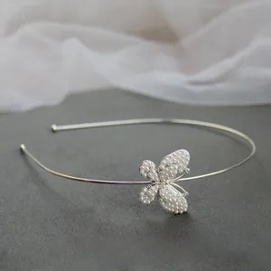 Dettaglio di un elegante cerchietto in lega d'argento con farfalla di perle e strass