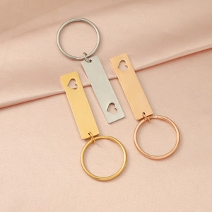 Close-up of gold, silver, and rose gold rectangular keychains with heart cut-outs