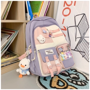 Detailed view of purple nylon school bag with transparent pocket, charms, and cute badges
