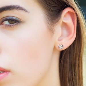 Close-up of a rose gold butterfly cartilage earring with sparkling zircon on ear