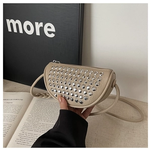 Detail of beige semi-circular crossbody bag with silver studs and lychee grain leather