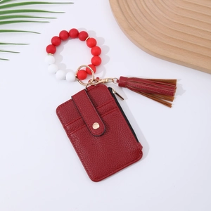 Detail of red leather card holder with silicone bead wristlet and elegant tassel