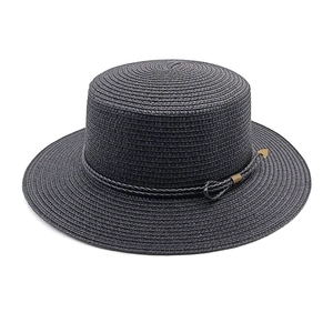 Close-up of black straw boater hat with fine weave and vintage gold arrow buckle detail